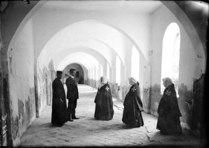 Un sacerdot, un altre home i tres monges a la galeria del monestir de Santa María de Sigena