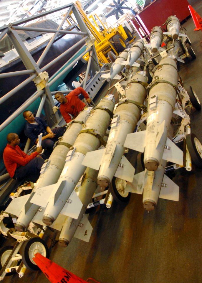 US Navy 060909-N-9915J-030 Aviation Ordnanceman study training material while standing watch over racks of GBU-38 Joint Attack Direct Munition bombs in the hangar bay aboard the nuclear-powered aircraft carrier USS Enterprise