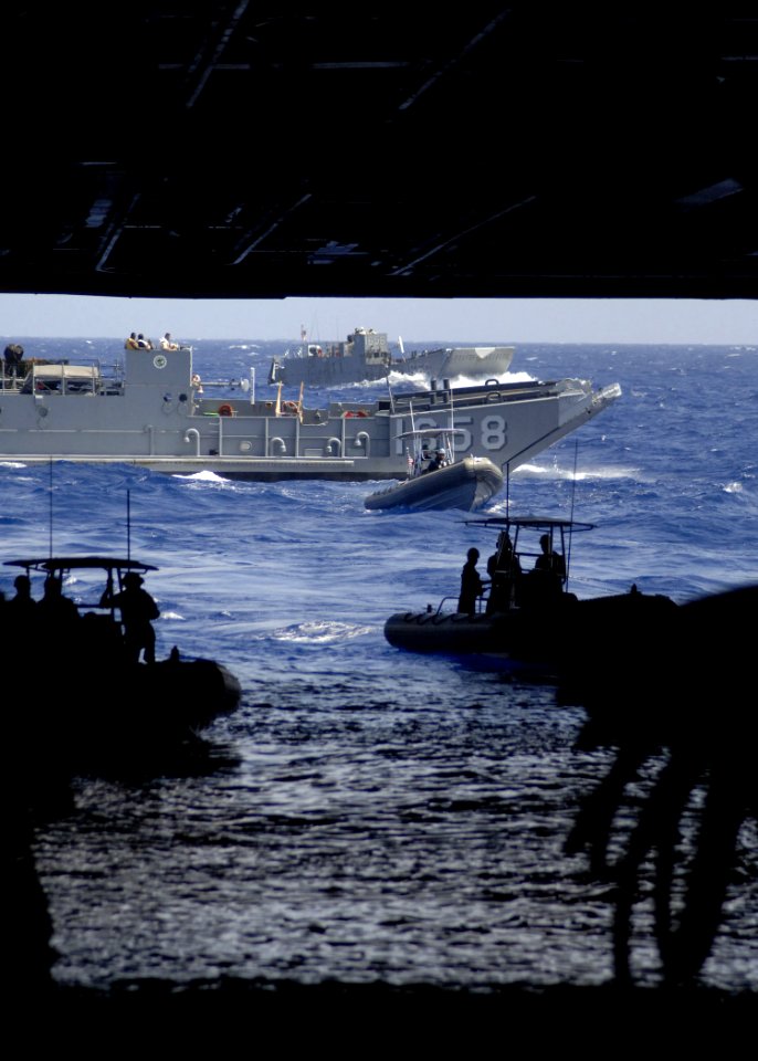 US Navy 060831-N-6616W-062 Landing Craft Utility (LCU) 1658 and several Ridged Hulled Inflatable Boats (RHIB) prepare to enter the well-deck aboard the amphibious assault ship USS Saipan (LHA 2)