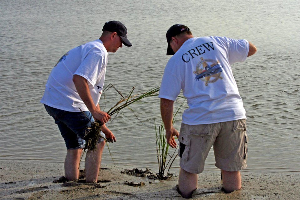 US Navy 060906-N-7441H-006 Storekeeper Seaman Apprentice Andrew Johnson (left) and Storekeeper 2nd Class Troy Smith, both assigned to the attack submarine USS Texas (SSN 775), replant marsh grass at Pierce Marsh