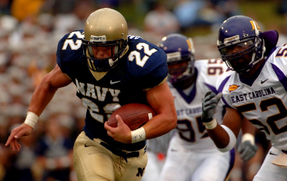 US Navy 060902-N-9693M-002 U.S. Naval Academy Midshipman fullback is chased by East Carolina defenders Jarrett Wiggins, 52, and C.J. Wilson, 95, in the first half of play at Navy - Marine Corps Memorial Stadium