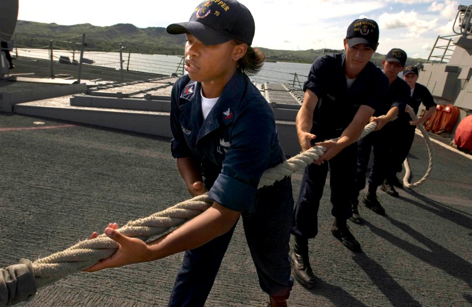 US Navy 060906-N-9851B-001 Information Systems Technician 2nd Class Chelsea McCalop heaves in a mooring line as the Arleigh Burke-class guided missile destroyer USS Hopper (DDG 70) prepares to depart Guam