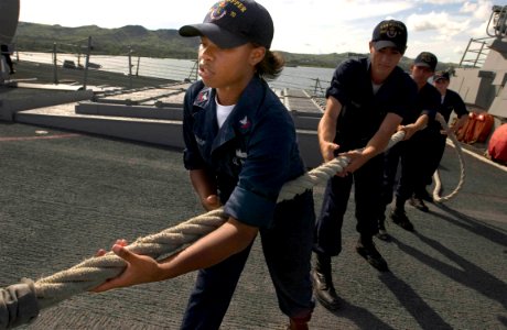 US Navy 060906-N-9851B-001 Information Systems Technician 2nd Class Chelsea McCalop heaves in a mooring line as the Arleigh Burke-class guided missile destroyer USS Hopper (DDG 70) prepares to depart Guam photo