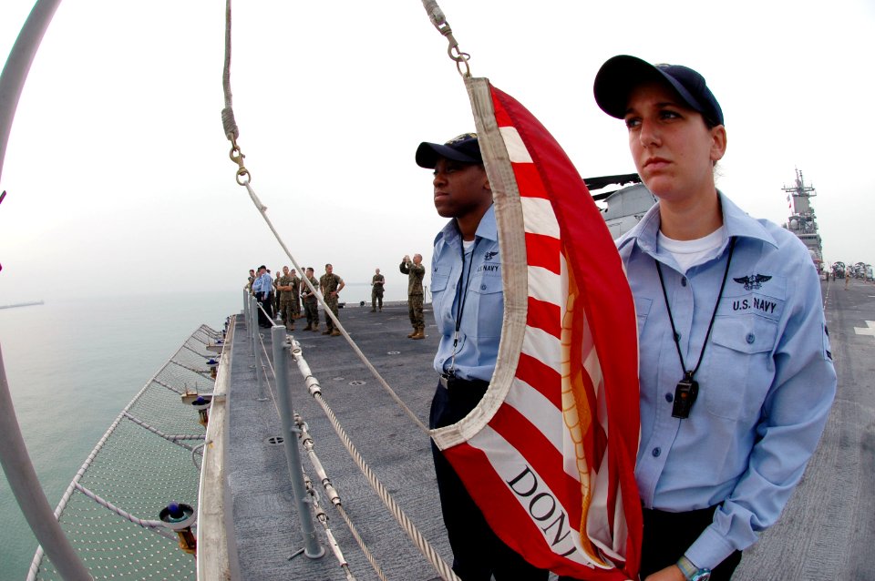 US Navy 061012-N-0209M-003 Aviation Boatswain's Mate-Handling 3rd Class Elizabeth King and Aviation Boatswain's Mate-Handling Airman Epiphany Elam prepare to shift colors on the ship's jackstaff
