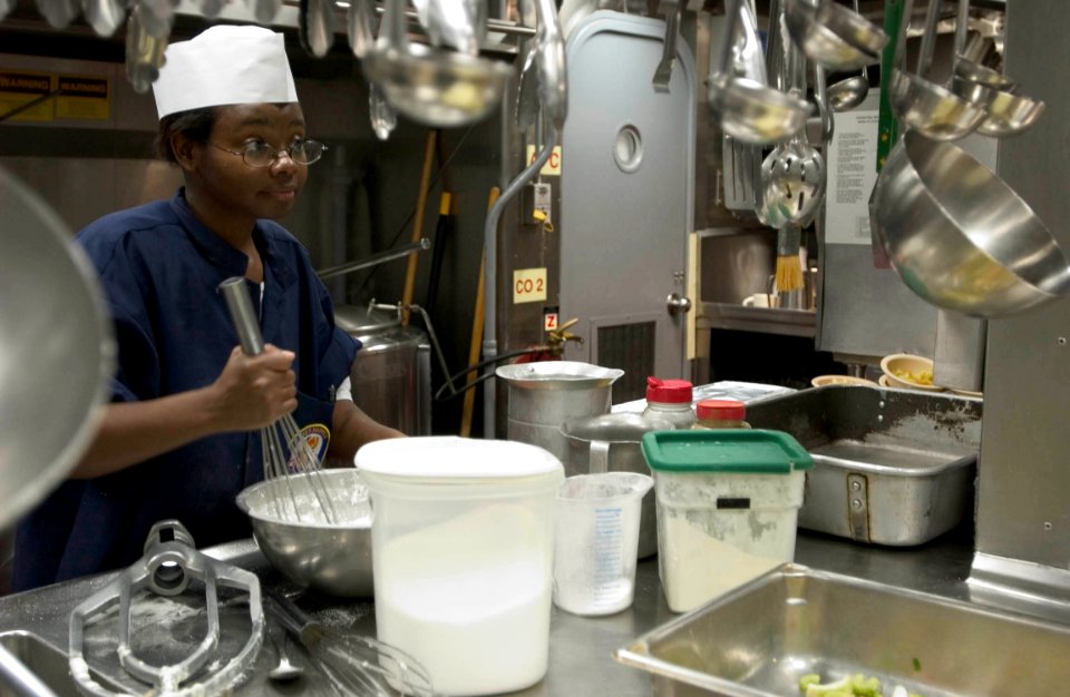 US Navy 060901-N-9851B-008 Culinary Specialist 3rd Class Bernica Yactzak makes dumplings from scratch, that will be on top of chicken pot pie to be served for evening meal aboard Arleigh Burke-class guided missile destroyer USS