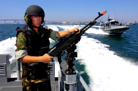 US Navy 060830-N-9818V-191 Gunner's Mate Seaman Justin Baker, assigned to Inshore Boat Unit One Three (IBU-13), mans a 7.62mm M-240 machine gun while conducting fast boat maneuvers during exercise Seahawk 2006 photo