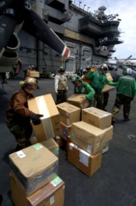 US Navy 060831-N-8604L-407 Sailors stack mail on the flight deck aboard USS Kitty Hawk (CV 63) prior to loading on board a C-2A Greyhound