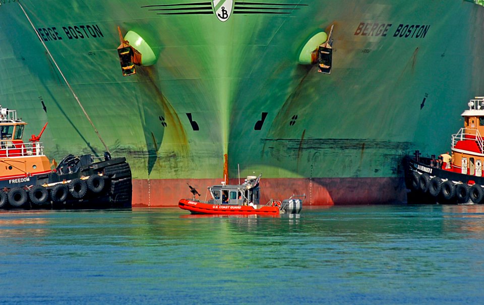US Navy 060908-C-2023P-500 A Coast Guard 25-foot response boat is flanked by two tugs as the Liquid Natural Gas (LNG) tanker Berge Boston is moored to the pier at an LNG facility in Boston
