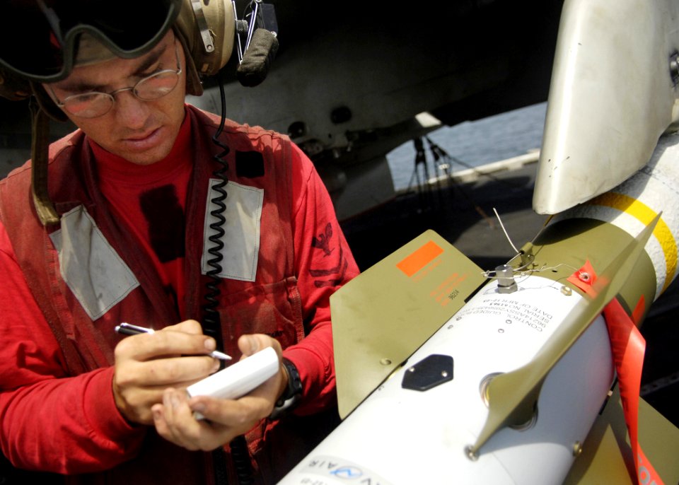 US Navy 060909-N-9742R-085 Aviation Ordnanceman 2nd Class Ryan Bauer, of Cedartown, Ga., verifies the serial numbers on components of a GBU-12 laser-guided bomb
