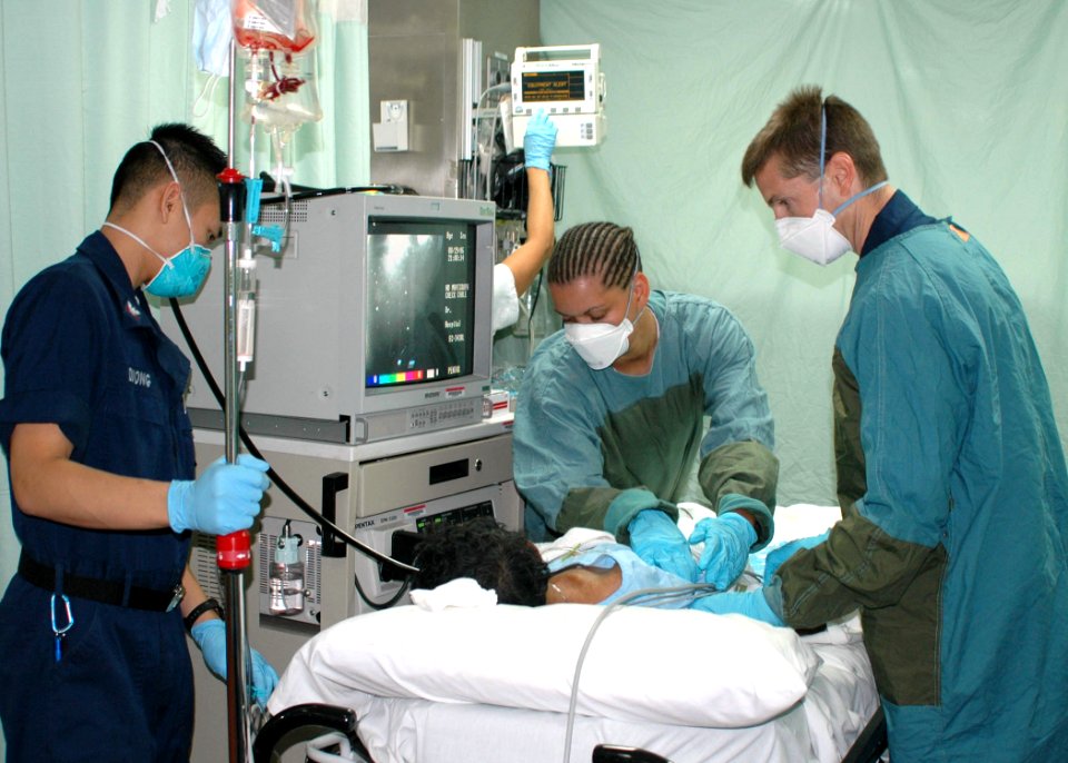 US Navy 060830-N-9076B-188 Lt. Cmdr. Todd Sheer, right, Hospital Corpsman 3rd Class Bryan Duong, left) and Hospitalman Shannon Dawkins, prepare to perform an endoscopies on a patient in casualty receiving on the Military Sealif