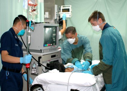 US Navy 060830-N-9076B-188 Lt. Cmdr. Todd Sheer, right, Hospital Corpsman 3rd Class Bryan Duong, left) and Hospitalman Shannon Dawkins, prepare to perform an endoscopies on a patient in casualty receiving on the Military Sealif photo