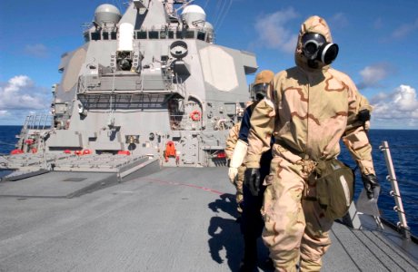 US Navy 060901-N-9851B-002 Hull Technician 3rd Class Marc Brandes wears an Advanced Chemical Protective Garment (ACPG) while leading an external survey team