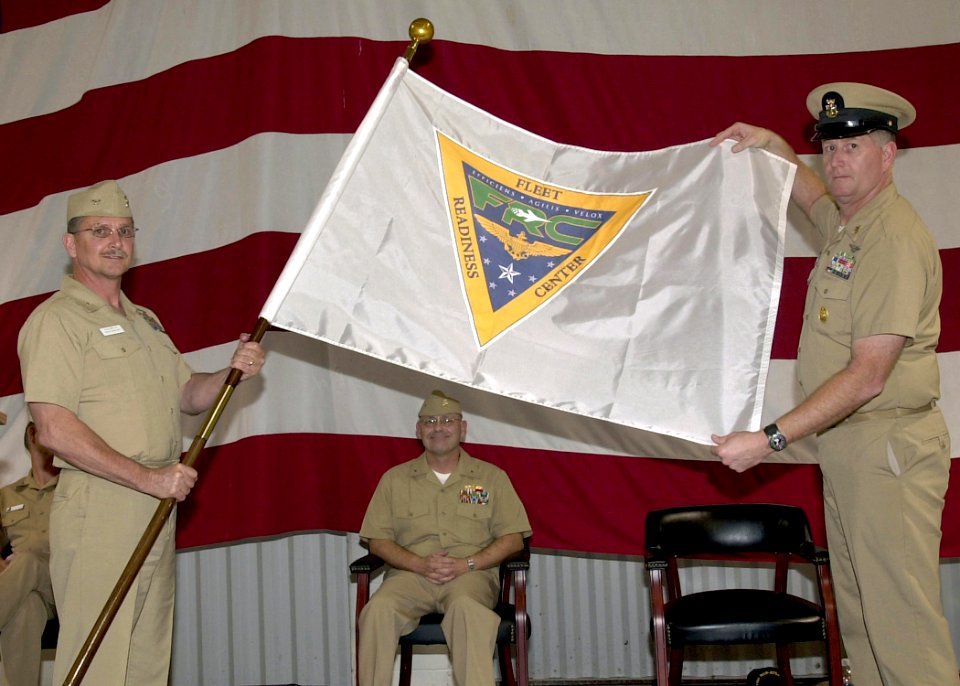 US Navy 061016-N-1082Z-002 Commander, Fleet Readiness Center (FRC) Rear Adm. Michael Hardee watches as the FRC flag is unveiled