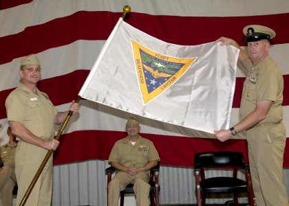 US Navy 061016-N-1082Z-002 Commander, Fleet Readiness Center (FRC) Rear Adm. Michael Hardee watches as the FRC flag is unveiled
