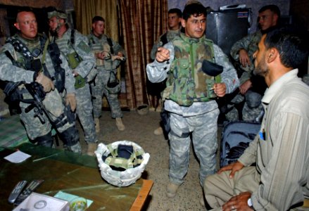 US Navy 061003-N-4097B-002 U.S. Army Soldiers talk to an Iraqi man at an Iraqi police station prior to conducting a search and seizure for insurgents in a village outside Baqubah, Iraq