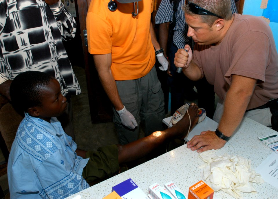 US Navy 060916-N-1328C-262 Hospital Corpsman 1st Class Brian Dessel from Doylestown, Pa., and stationed at the Medical Center, Bahrain, examines a boy's leg as part of a Medical Civic Action Program (MEDCAP in Hindi, Kenya
