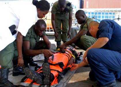 US Navy 061004-N-0000X-001 A Sailor assigned to the guided missile frigate USS Elrod (FFG 55) (right) works with Ghanaian army auxiliary nurses on personnel casualty transport techniques aboard the ship
