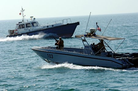 US Navy 061017-N-8148A-047 A harbor patrol boat unit from Naval Security Force Bahrain pauses during an escort mission to let the harbor pilot boat pass