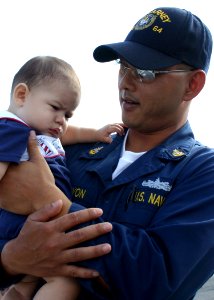 US Navy 060908-N-8544C-042 Senior Chief Hospital Corpsman Torsak Vimoktayon holds his six-month old son upon his return to Mayport photo