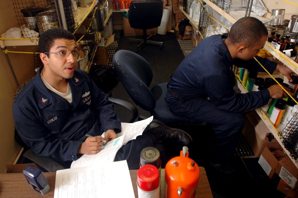 US Navy 061025-N-1332Y-174 Storekeeper 3rd Class Freddy Cruz from New York City, and Aviation Support Equipment Technician 3rd Class Daniel Brown from Los Angeles, complete a customer's paint order