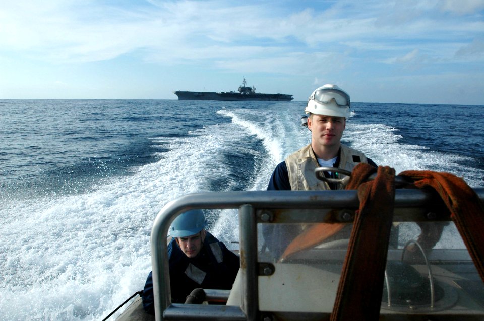 US Navy 061020-N-1332Y-008 Boatswain's Mate 2nd Class Joshua Young, right, and Engineman 2nd Class Ryan Zehr drive away from USS Kitty Hawk (CV 63) to rescue Oscar
