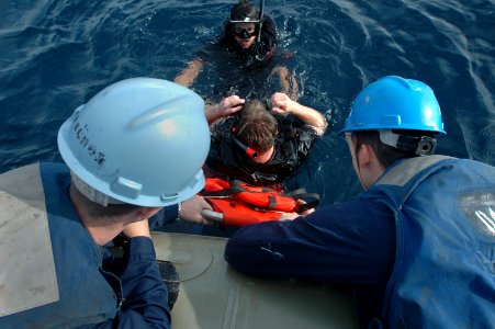 US Navy 061020-N-1332Y-367 USS Kitty Hawk (CV 63) Sailors prepare to pull Aviation Ordnanceman Airman Tim Tuttle, playing the role of a man overboard, into a rigid hull inflatable boat (RHIB)