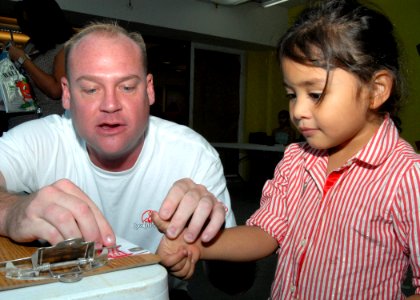 US Navy 061028-N-9662L-018 Petty Officer 1st Class Daniel Jones, a Sailor assigned to Naval Computer Telecommunications Station (NCTS) Guam, fingerprints Alexis Kosak during the 11th annual Project KidCare event held at Agana S photo