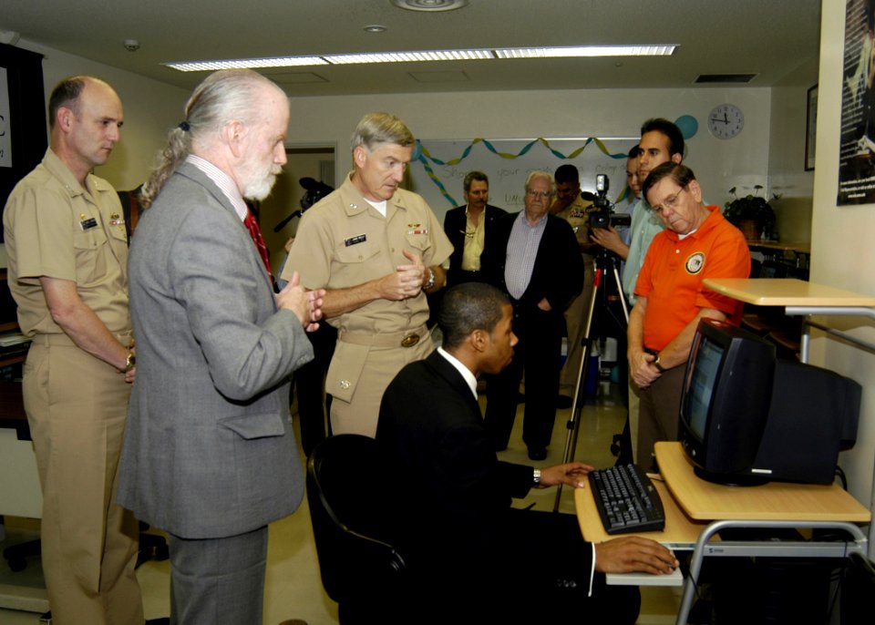 US Navy 061025-N-4649C-034 Capt. Gregory Cornish, University of Maryland University College Director Paul Brewer, and Commander, Naval Forces Japan Rear Adm. James Kelly observe a demonstration of a computerized College Level E
