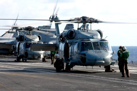 US Navy 061023-N-6106R-084 Two MH-60S Seahawks wait to be refueled on the flight deck aboard USS Kitty Hawk (CV 63) during a vertical replenishment with Military Sealift Command ammunition ship USNS Flint (T-AE 32)