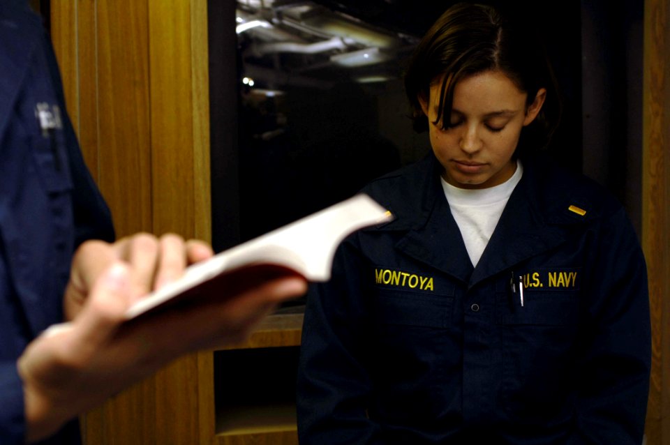 US Navy 061022-N-5330L-544 Ensign Laura Montoya, lay leader for the Catholic service aboard guided-missile cruiser USS Anzio (CG 68), bows her head in prayer
