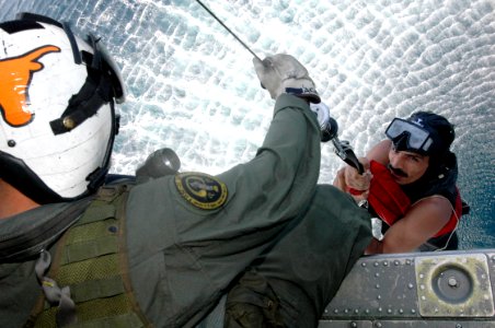 US Navy 061028-N-0209M-002 A Sailor assigned to Explosive Ordnance Disposal Mobile Unit Three (EODMU-3) detachment 11 deployed aboard the amphibious assault ship USS Boxer (LHD 4) assist an Indian soldier into a helicopter duri photo