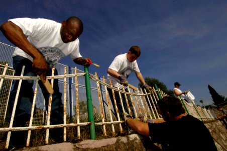 US Navy 061025-N-5330L-204 Sailors from the guided missile cruiser USS Anzio (CG 68) scrape rust off the landscape at Mladost children's home in Bijela