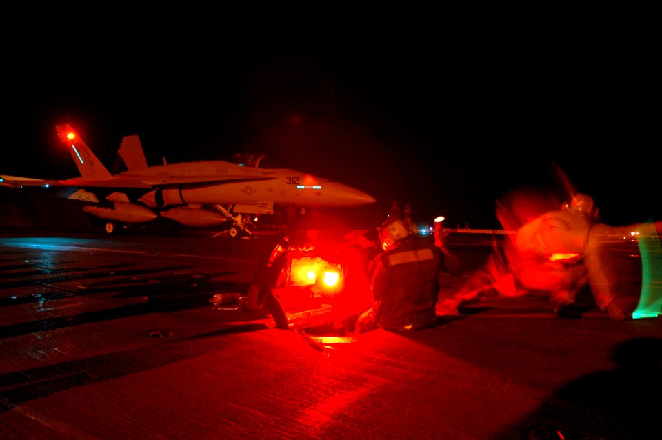 US Navy 061027-N-6106R-139 A shooter launches an F-A-18C Hornet, assigned to Strike Fighter Squadron One Nine Two (VFA-192), off the flight deck of USS Kitty Hawk (CV 63) during nighttime cyclic flight operations