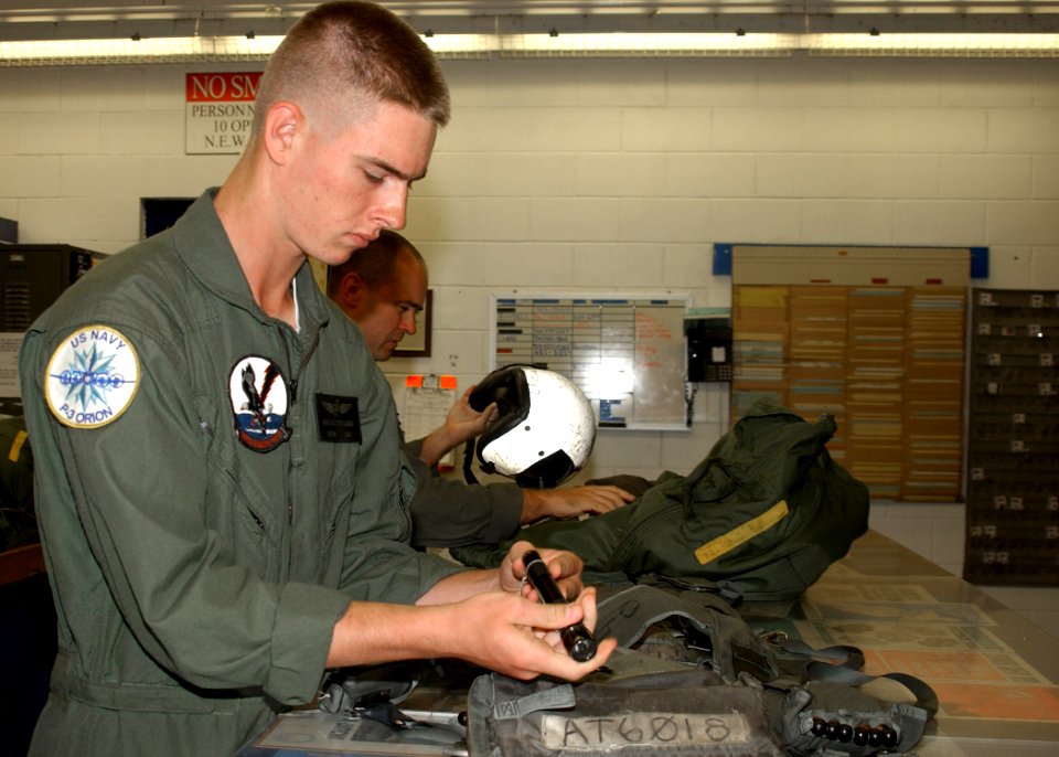 US Navy 061101-N-1810F-004 Aviation Electronics Technician Airman Apprentice Aaron G. Ferchland assigned to Patrol Squadron Three Zero (VP-30) inspects his survival gear before a training flight