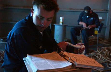 US Navy 061024-N-4133B-116 Boatswain's Mate Seaman Ronnie Davis from Fresno, Calif., reads an instruction on splicing line aboard USS Ronald Reagan (CVN 76)
