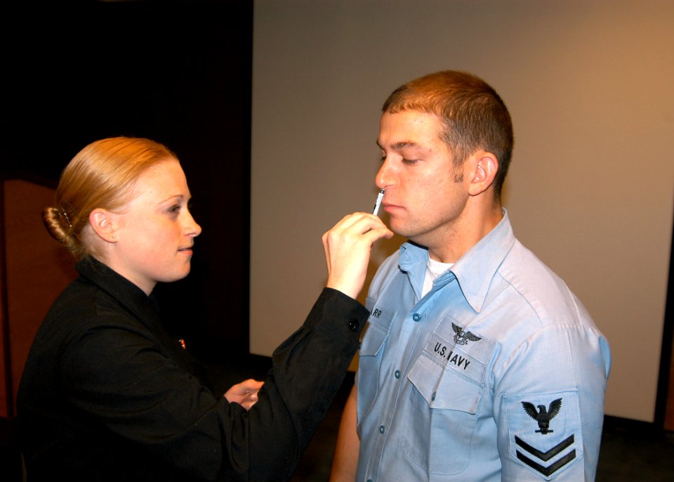 US Navy 061030-N-6247M-002 Aviation Boatswain's Mate Fuels 2nd Class Joshua Karr receives a Influenza Virus Vaccine Live, Intranasal Flu Mist from Hospital Corpsman Nicole McQueen