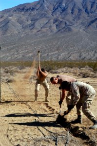 US Navy 061106-N-6999H-039 Sailors assigned to Naval Coastal Warfare Squadron Five (NCWS-5) and Explosive Ordnance Disposal Group One (EODG-1) work together to dig a foundation for a communications antenna to a joint task force