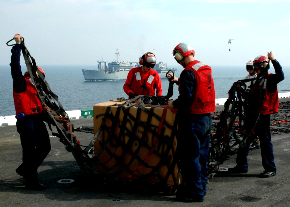US Navy 061104-N-8547M-082 Sailors assigned to the weapons department aboard USS Saipan (LHA 2) prepare pallets for pickup during a vertical replenishment