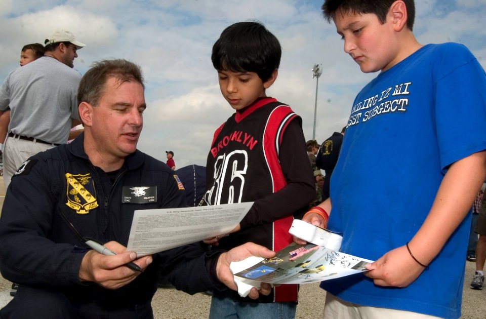US Navy 061105-N-3750S-133 Chief Engineman Dave Casper, left, a member of the U.S. Navy Parachute Team, the Leap Frogs, chats about his Navy career and signs autographs