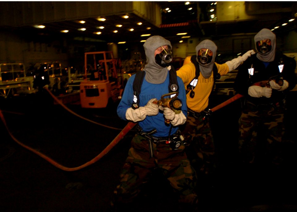 US Navy 061104-N-9723W-019 Hose team members move in to fight a simulated hangar bay fire during a general quarters drill
