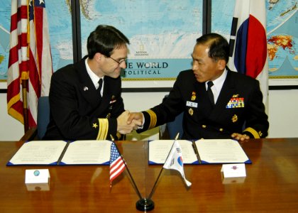 US Navy 061108-N-4649C-001 Commander, Submarine Group Seven Rear Adm. John Bird (left), shakes hands with Commander, Korean Submarine Force Rear Adm. Il Heon Bae, after signing the Mutual Logistics Support Agreement photo