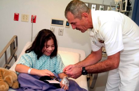US Navy 061108-N-3750S-140 Chief Master-at-Arms Ed Stift shares coins and talks with a young girl at Methodist Children's Hospital photo