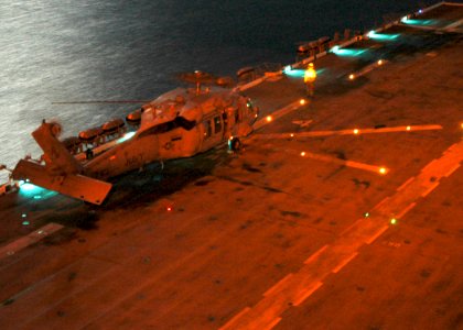 US Navy 061103-N-8547M-057 An MH-60S helicopter refuels on the flight deck of amphibious assault ship USS Saipan (LHA 2) during night flight operations