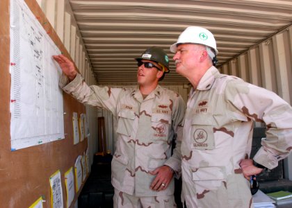 US Navy 061109-N-1328C-048 U.S. Navy Steel Worker 1st Class Dennis Ryan attached to Naval Mobile Construction Battalion Five (NMCB-5) shows Commander 1st Naval Construction Division, Rear Adm. Robert Phillips, the progress of t