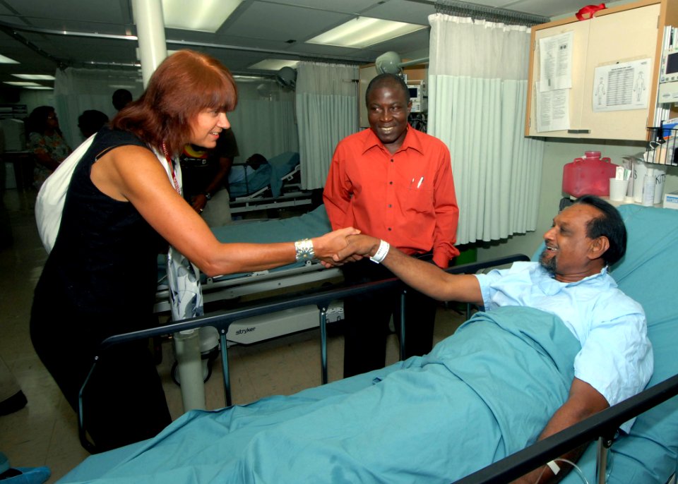 US Navy 071004-N-8704K-056 Ambassador Lisa Bobbie Schreiber Hughes, U.S. ambassador to Suriname, greets a patient awaiting an operation as Michel Felisi, acting Suriname Minister of Health, looks on during a tour of USNS Comfor