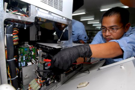 US Navy 071005-N-8704K-022 Hospital Corpsman 1st Class Ervin Abalos, attached to the Military Sealift Command hospital ship USNS Comfort (T-AH 20), repairs a chemical analyzer at the Academische Hospital in Paramaribo, Suriname photo
