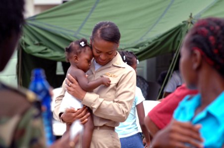 US Navy 071005-N-0194K-120 Lt. Cmdr. Andrea Petrovanie, attached to the Military Sealift Command hospital ship USNS Comfort (T-AH 20), calms a pediatric patient at Flustraat Clinic in Paramaribo, Suriname photo