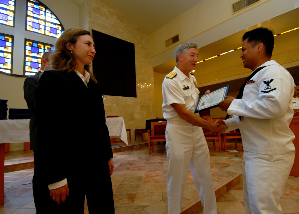 US Navy 071005-N-4399G-068 Rear Adm. James D. Kelly, commander of U.S. Naval Forces Japan, congratulates Culinary Specialist 3rd Class Jamie Manzon, assigned to USS Blue Ridge (LCC 19), as he presents him with a certificate of