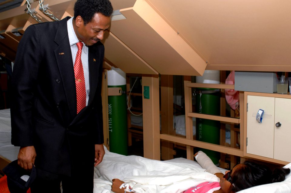 US Navy 071006-N-7088A-212 The Republic of Suriname Minister of Defense Ivan Fernald greets a patient in a recovery ward while on a tour of the Military Sealift Command hospital ship USNS Comfort (T-AH 20), off the coast of Sur