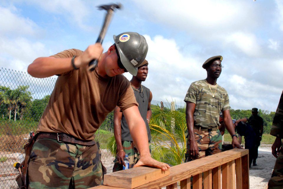 US Navy 071004-N-7092S-012 Builder 2nd Class William Lathan, a Seabee assigned to Military Sealift Command hospital ship USNS Comfort (T-AH 20), drives a nail into a gazebo at the Zanderij Clinic